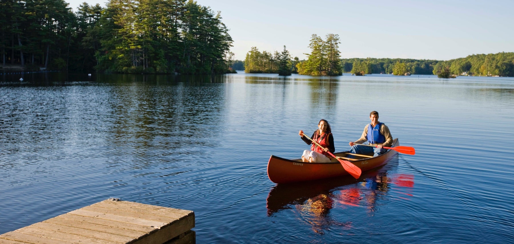 A couple canoeing on Pawtuckaway Lake in New Hampshire's Pawtuckaway State Park.